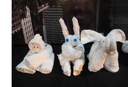 Photo shows a rabbit, an elephant, and an eskimo made out of white towels.